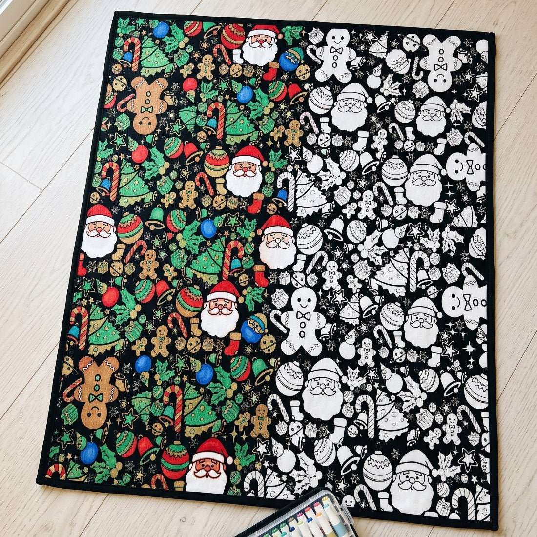 The blanket laid flat, half of the drawings colored in and half still black and white